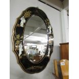 An oval lacquered mirror with Japanese figures.
