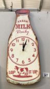 A metal milk bottle advertising sign wall clock.