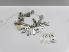 A silver charm bracelet with silver padlock and 13 charms.