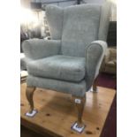 A Parker Knoll style armchair on queen anne legs.