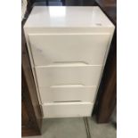 A white painted chest of 4 drawers.