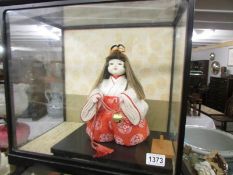 A cased Japanese 'Ichimatsu' Gotun doll with glass eyes.