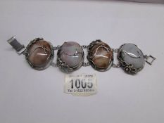 A white metal bracelet with 4 large coloured stones.