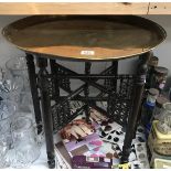 An indian folding table with brass tray top.