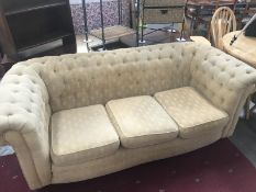 A deep buttoned fabric covered chesterfield sofa.