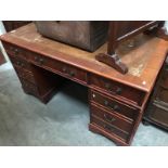 A wooden desk with leather insert on top.