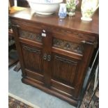 A linen-fold carved side cupboard.