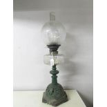 A Victorian Hinks oil lamp with clear glass font and acid etched shade on a tall cast iron base.