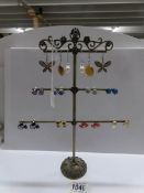 An earring stand with 11 pairs of earrings.