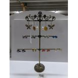 An earring stand with 11 pairs of earrings.