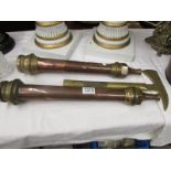 2 brass and copper fireman's hoses together with a fireman's axe.
