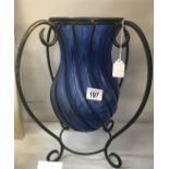 A wrought iron and blue glass bowl.