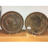 2 metal plaques depicting Roman soldiers.