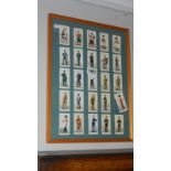 A framed and glazed set of 25 military uniform cigarette cards.