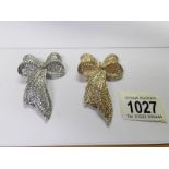 2 jewelled bow brooches, one gold coloured and the other silver coloured.