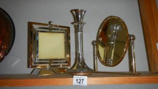 A mirror, a candlestick and a photo frame.
