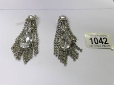 A pair of drop earrings set white stones.