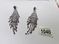A pair of drop earrings set amethyst coloured stones.