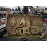 A cottage dolls house designed and made by Mike Marsden along with dolls house furniture etc.