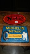 A cast iron Norton sign and a cast iron Michelin sign.
