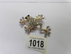 A jewelled frog brooch set white stones.