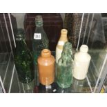 3 old glass bottles and 3 stoneware bottles.