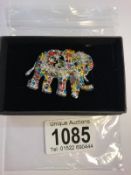 An elephant brooch set coloured stones.