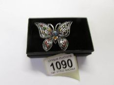 A jewelled butterfly brooch.