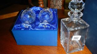 A boxed square style decanter bearing a crest and a boxed pair of brandy goblets.