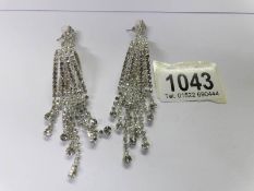 A pair of drop earrings set white stones.