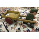 A vintage wooden pull a long toy featuring man & trailer.