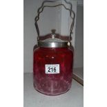 A cranberry glass biscuit barrel.