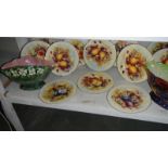 12 fruit decorated plates and 2 vases.