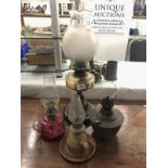 An oil lamp on metal base, 2 hand oil lamps and a brass oil lamp font.