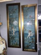 A pair of framed and glazed cherub pictures.