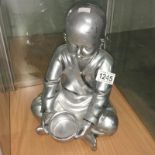 A silver coloured Buddha as a boy.