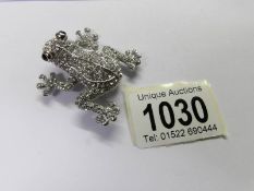 A jewelled frog brooch.