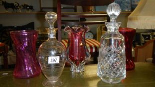 3 cranberry glass vases and 2 decanters.