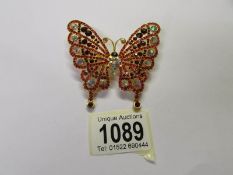 A large jewelled butterfly brooch.