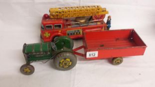 A Mettoy tinplate clockwork tractor and trailer, and a tinplate friction fire engine.
