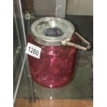 A cranberry glass biscuit barrel.