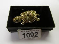 A jewelled tortoise brooch with articulated head.
