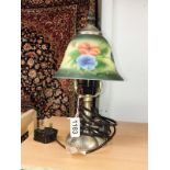A table lamp with floral decorated glass shade.