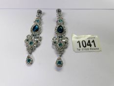 A pair of drop earrings set white stones.