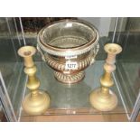 A copper wine cooler and a pair of brass candlesticks.
