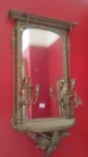 A pair of mirrors in gilt frames with candle sconces