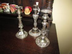 A pair of silver plated candlesticks and one other.
