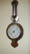 A Victorian barometer/thermometer with brass decorations,