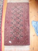 A Persian fringed rug 54cm x 43cm