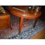 A large extending teak table with two leaves